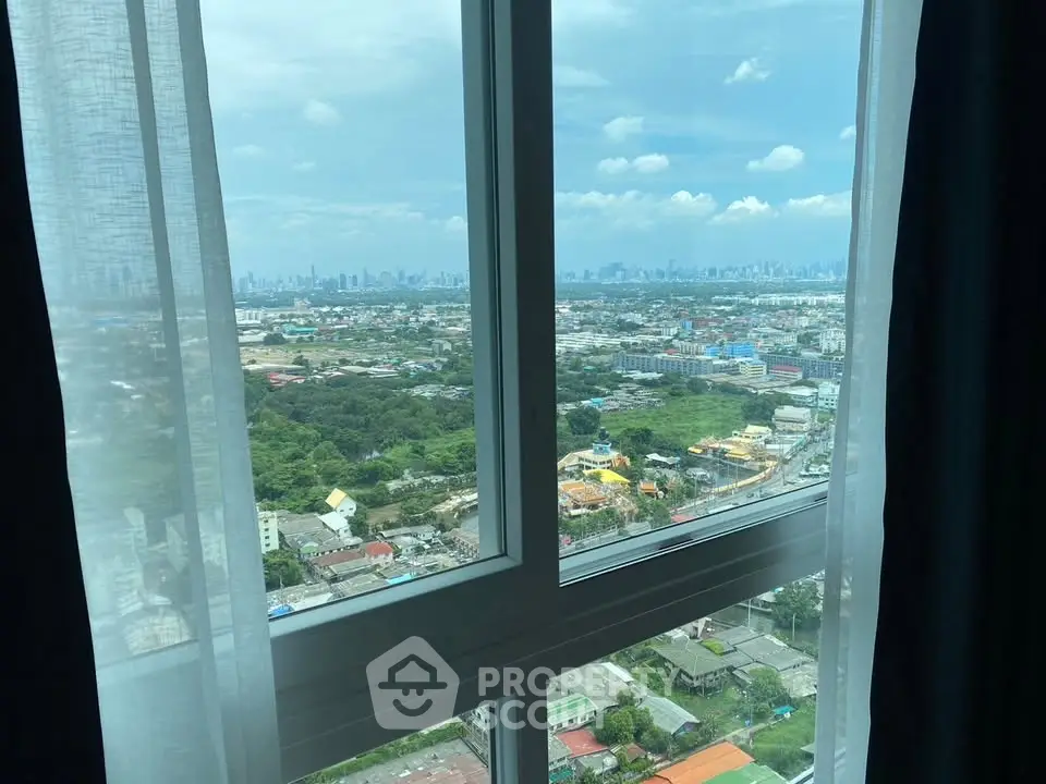 Stunning cityscape view from a high-rise apartment window, showcasing urban skyline and lush greenery.