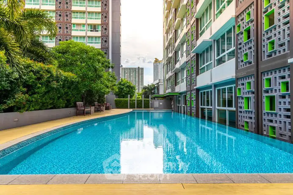 Luxurious condominium with a stunning outdoor pool and lush greenery, perfect for relaxation and leisure.