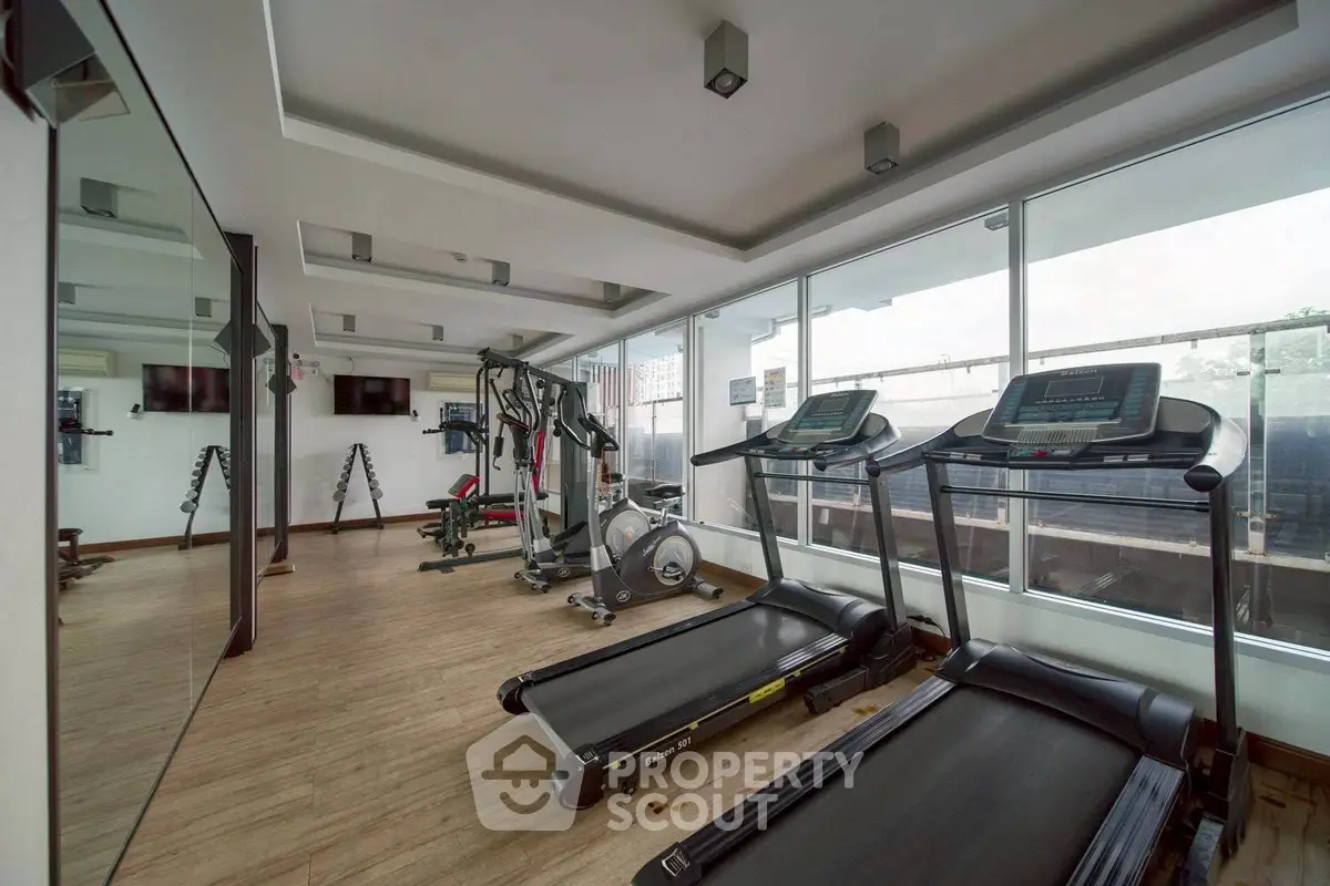 Modern gym with treadmills and exercise equipment in a bright, spacious room.