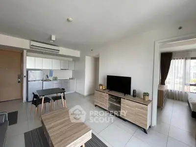 Modern open-plan living room with sleek kitchen and cozy bedroom view