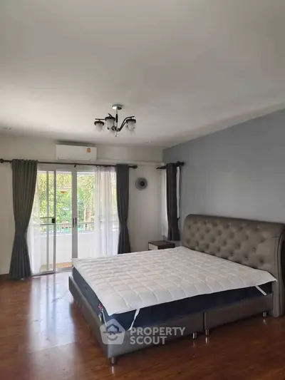 Spacious bedroom with elegant bed and balcony view