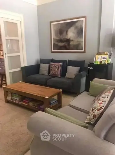 Cozy living room with stylish sofas and a wooden coffee table, perfect for relaxation and family gatherings.