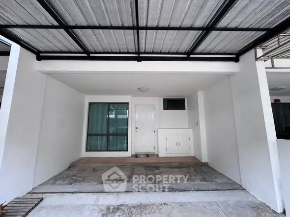 Modern covered parking space with sleek design and secure entrance in residential property.