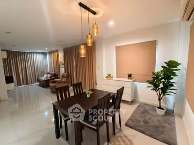 Spacious modern living room with elegant dining area and stylish lighting in a contemporary apartment.