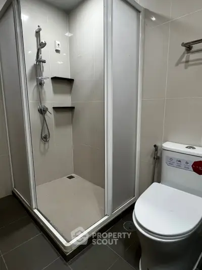 Modern bathroom with sleek shower enclosure and contemporary toilet design.