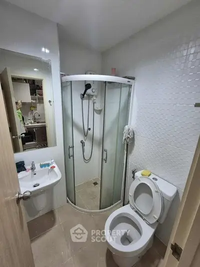 Compact bathroom with shower cabin and modern fixtures in a cozy apartment.