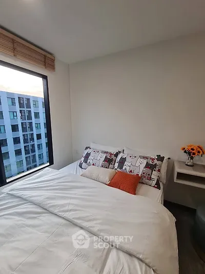 Cozy bedroom with large window and modern decor in urban apartment