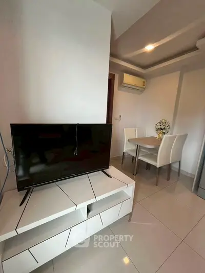 Modern living room with sleek TV stand and dining area, perfect for cozy gatherings.