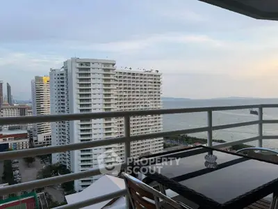 Stunning ocean view from high-rise balcony with modern outdoor seating.