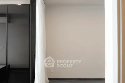 Minimalist bedroom with sleek black wardrobe and white curtains