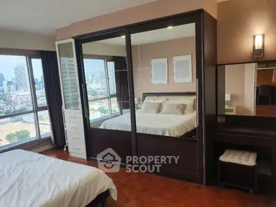 Spacious bedroom with city view and elegant mirrored wardrobe