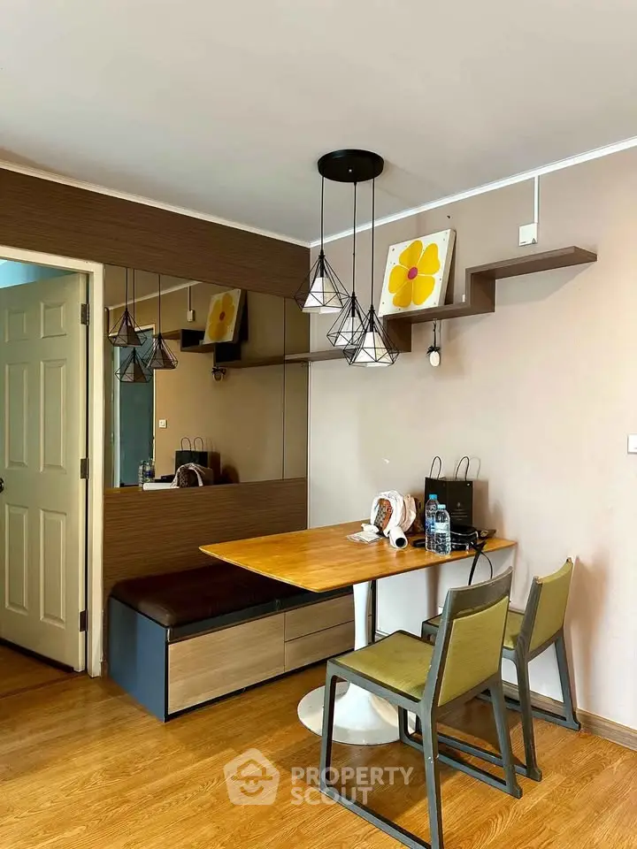 Charming dining area with modern lighting and cozy seating in a stylish apartment.