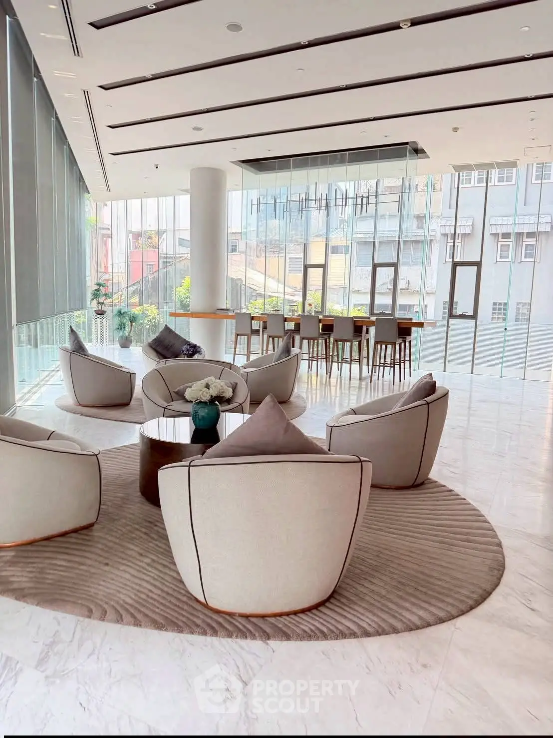 Luxurious modern lobby with elegant seating and floor-to-ceiling windows offering city views.