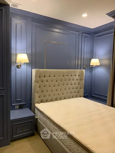 Luxurious bedroom with elegant blue paneling and plush headboard