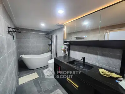 Modern bathroom with sleek black vanity and freestanding bathtub