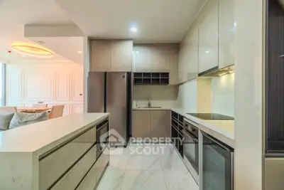 Modern kitchen with sleek cabinetry and open layout adjacent to elegant living area.