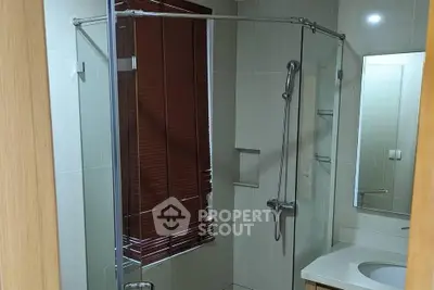 Modern bathroom with glass shower enclosure and sleek fixtures.