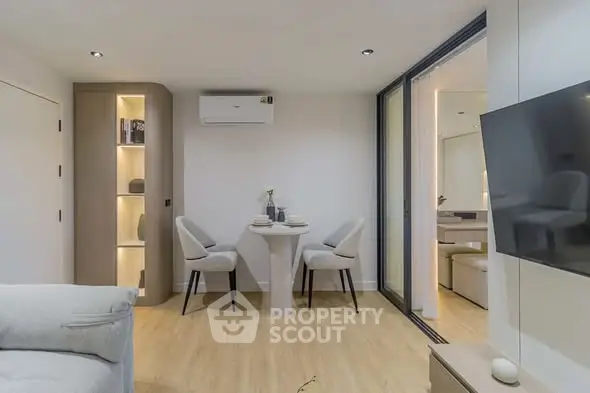 Modern living room with sleek furniture and open layout, featuring a cozy dining area and stylish decor.