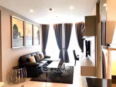 Modern living room with stylish decor and ample natural light, featuring a comfortable sofa and elegant curtains.