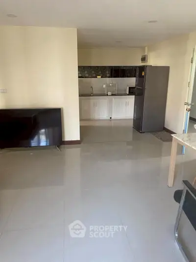 Spacious open-plan living area with modern kitchen and sleek appliances.