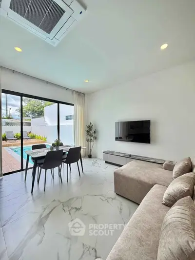 Modern living room with pool view, featuring sleek furniture and elegant decor, perfect for luxury living.