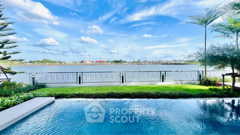 Stunning waterfront view with private pool and lush garden, perfect for luxury living.