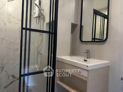 Modern bathroom with sleek shower and stylish vanity in contemporary apartment.
