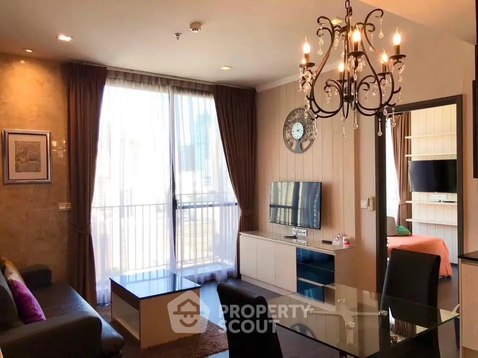 Elegant living room with chandelier and city view, featuring modern decor and natural light.