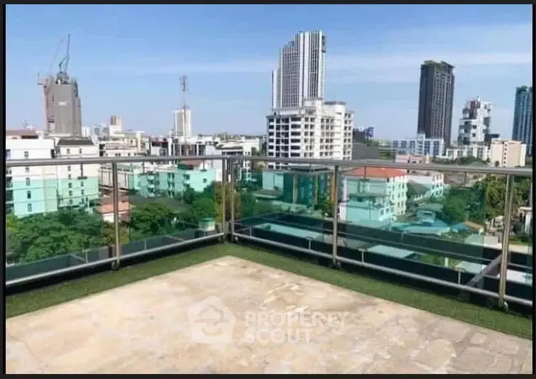 Stunning rooftop view of city skyline with modern glass railing and urban landscape.