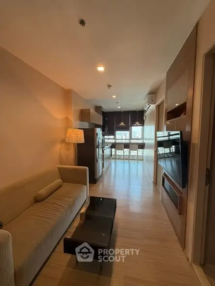 Modern living room with cozy sofa and open kitchen layout, perfect for urban living.