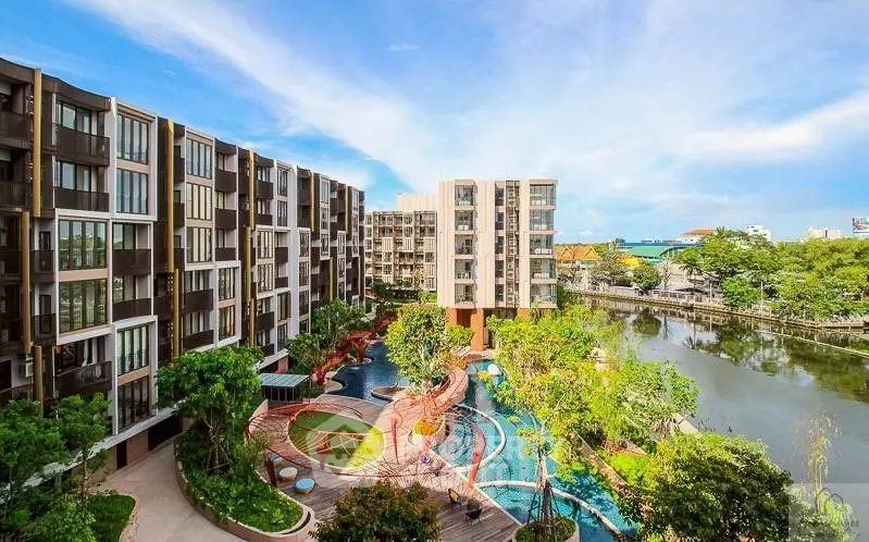 Stunning modern apartment complex with lush gardens and serene water views.