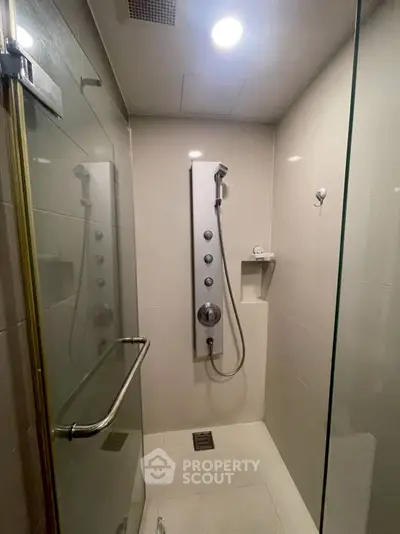 Modern bathroom with sleek shower panel and glass enclosure, perfect for a contemporary home.