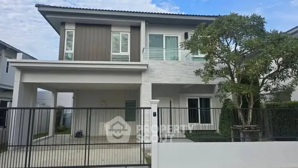 Modern two-story house with sleek design and spacious driveway.