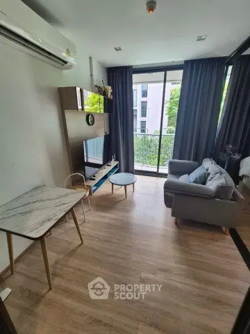 Modern living room with large windows and stylish furniture in a cozy apartment.