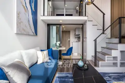 Modern duplex living room with stylish blue sofa and elegant staircase