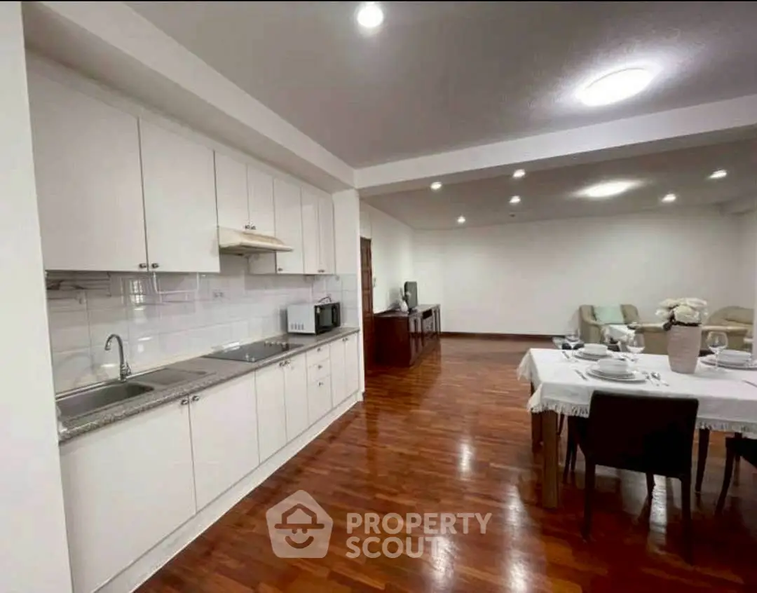 Spacious open-plan kitchen and living area with elegant wooden flooring.