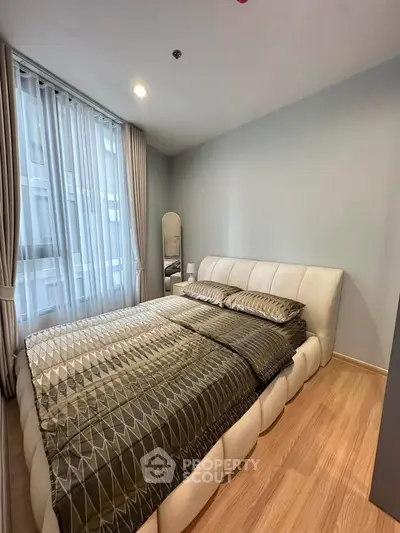 Modern bedroom with stylish decor and large window in a contemporary apartment.