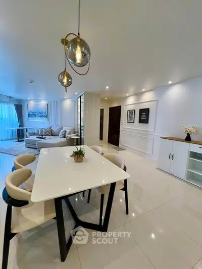 Luxurious modern living room with elegant dining area and stylish lighting fixtures.