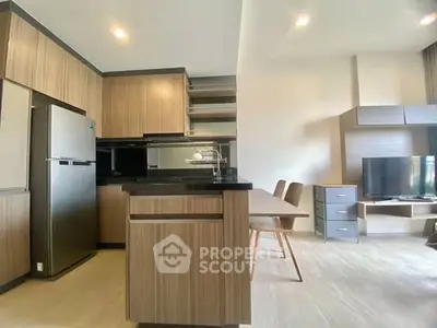 Modern kitchen and living area with sleek wooden cabinetry and open layout.