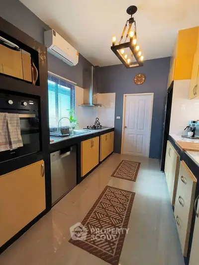 Modern kitchen with sleek appliances and stylish lighting in a cozy home.