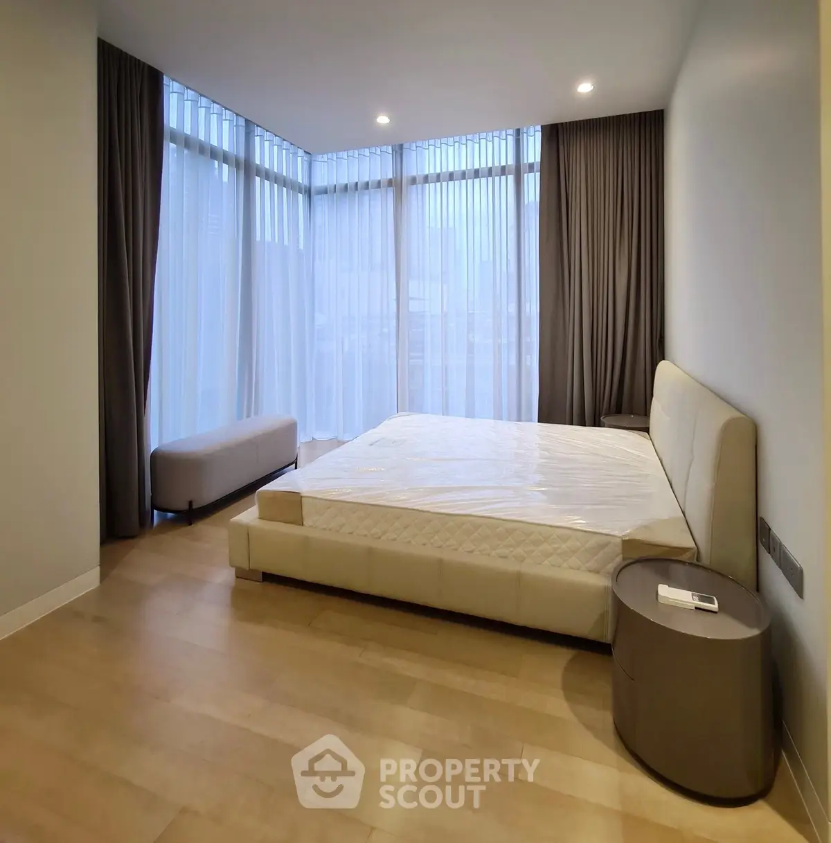 Spacious modern bedroom with large windows and elegant furnishings