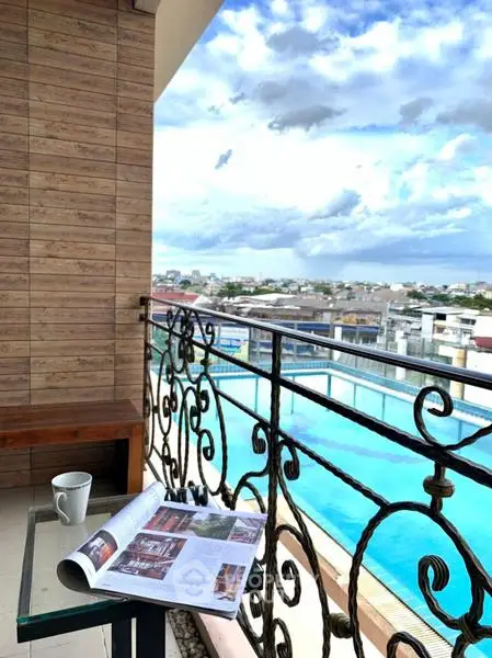 Stunning balcony view with pool and cityscape, perfect for relaxation and leisure.