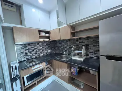 Modern kitchen with sleek cabinetry and stylish backsplash in a compact layout.