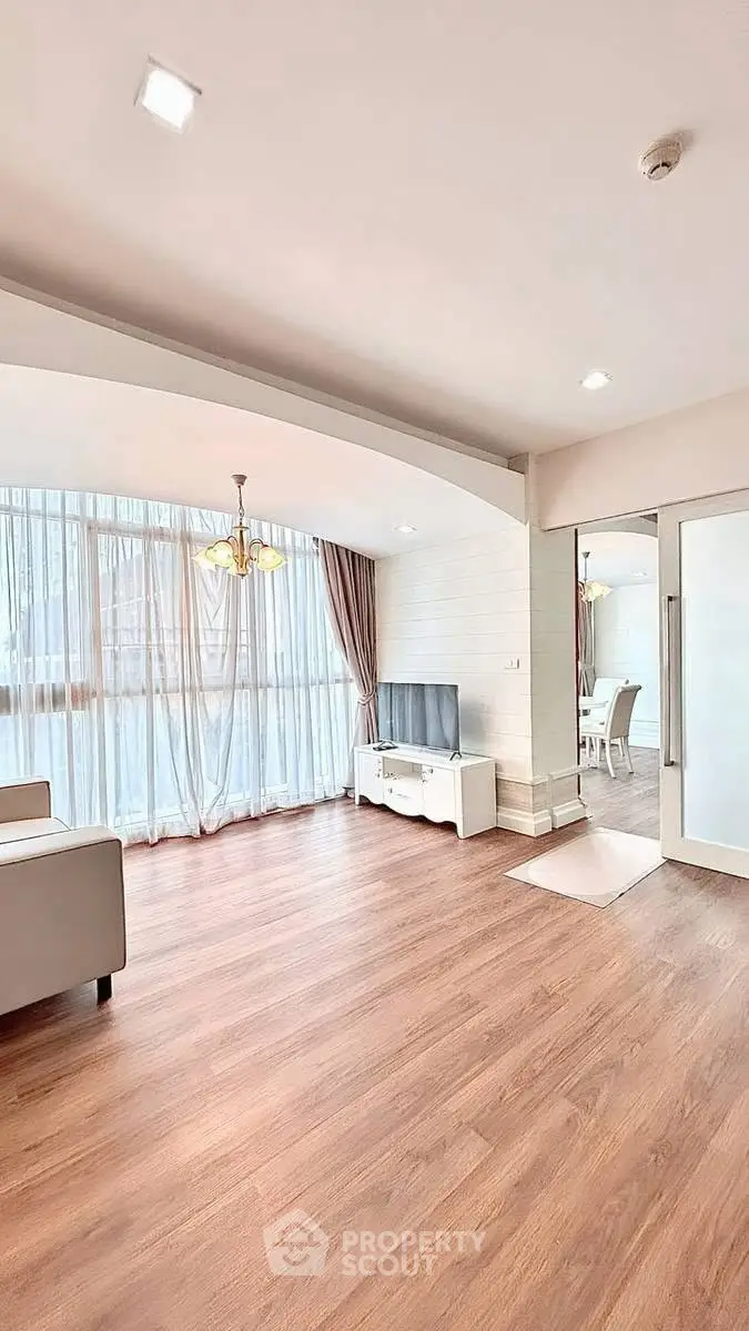 Spacious living room with elegant wooden flooring and natural light