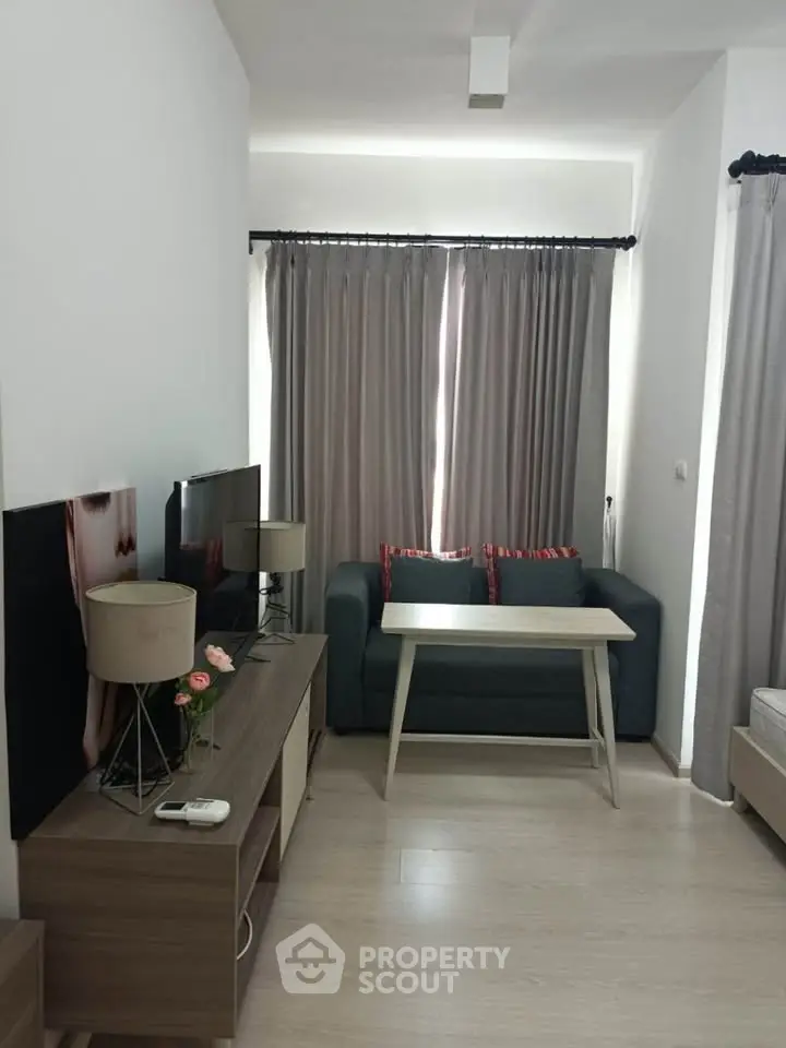 Cozy living room with modern decor, featuring a stylish sofa, sleek TV stand, and elegant curtains.