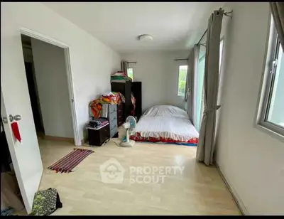 Cozy bedroom with natural light and minimalist decor, perfect for relaxation.