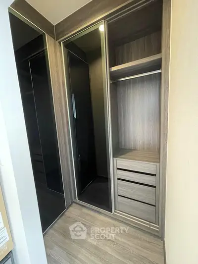 Modern walk-in closet with sleek wooden finish and ample storage space.