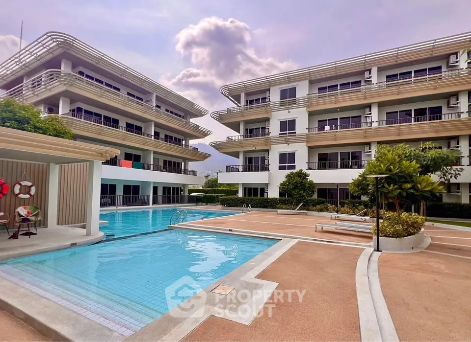 Modern apartment complex with pool and lush landscaping, perfect for luxury living.