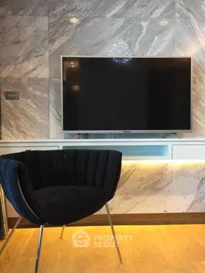 Modern living room with sleek TV and stylish chair on wooden floor