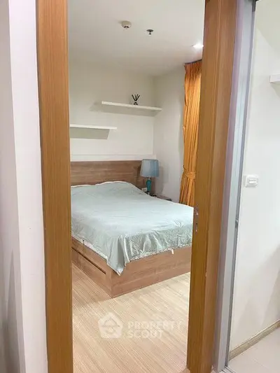 Cozy bedroom with wooden flooring and modern decor in a stylish apartment.